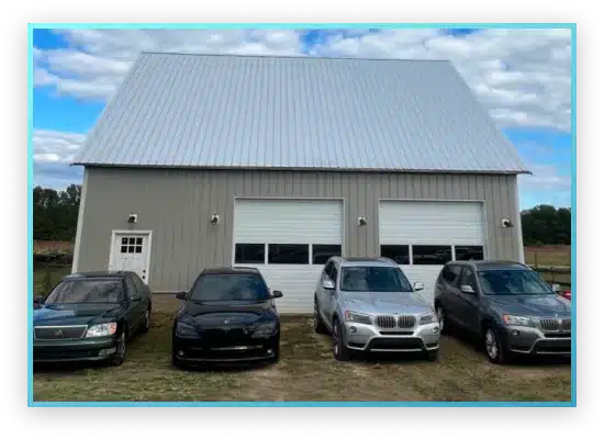 A beige metal building with a tall roof, featuring two large garage doors and a white entry door.