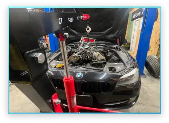 Image of a lifted BMW engine during repair.